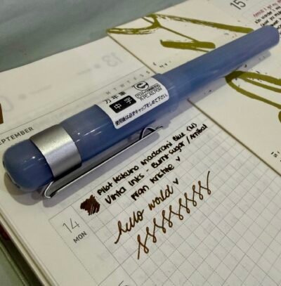 Pilot Kakuno Madoromi blue fountain pen on a notebook, with text written on the notebook to test fountain pen ink
